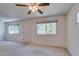 Bright living room featuring neutral carpet, windows, and a ceiling fan for comfortable living at 1127 Melville Dr, Las Vegas, NV 89102