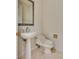 Elegant powder room with a pedestal sink, white fixtures, and decorative mirror at 11527 Morning Grove Dr, Las Vegas, NV 89135