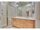 Well-lit bathroom boasts a walk-in shower, neutral countertops and wood cabinets at 11527 Morning Grove Dr, Las Vegas, NV 89135