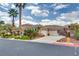 Spacious driveway of single-story home with desert landscaping and an attached three-car garage at 11527 Morning Grove Dr, Las Vegas, NV 89135