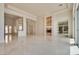 Open-concept living room with marble floors, fireplace, and a partial view of a window and chandelier at 11527 Morning Grove Dr, Las Vegas, NV 89135