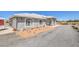 Charming single-story home with a white tiled roof, gray stucco, and a desert landscape at 1410 Tiptop Trl, Pahrump, NV 89048