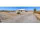 Charming home on a large lot featuring xeriscaped landscaping, a long driveway, and desert surroundings at 1410 Tiptop Trl, Pahrump, NV 89048