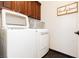 Laundry room complete with washer, dryer and wood cabinets at 145 Austin Rose Ave, Henderson, NV 89002