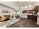 Spacious living area with seamless flow between the kitchen, dining, and living areas. Dark floors and white walls at 145 Austin Rose Ave, Henderson, NV 89002