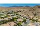 Wide aerial view showcasing desert neighborhood near mountains with mature landscaping at 145 Austin Rose Ave, Henderson, NV 89002