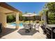 Covered patio with outdoor furniture, grill, umbrella, and swimming pool in the background at 145 Austin Rose Ave, Henderson, NV 89002
