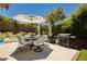 Backyard patio with outdoor furniture, grill, umbrella, and swimming pool in the background at 145 Austin Rose Ave, Henderson, NV 89002