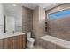 Stylish bathroom with a modern vanity, soaking tub, tiled walls, and a bright window at 1548 Pleasant Bay Ct, Henderson, NV 89011