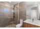 Bathroom featuring a glass-enclosed shower, modern vanity, and neutral tile at 1548 Pleasant Bay Ct, Henderson, NV 89011