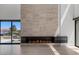 Modern fireplace with stone surround, set against an open-concept living area with lake views at 1548 Pleasant Bay Ct, Henderson, NV 89011