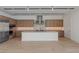 Modern kitchen featuring natural wood cabinetry, a center island, and tile floors at 1548 Pleasant Bay Ct, Henderson, NV 89011