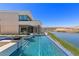 Infinity pool adjacent to lake with patio, stunning lake views and modern home architecture at 1548 Pleasant Bay Ct, Henderson, NV 89011