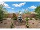 Backyard garden featuring a stone fountain, rock groundcover, lush greenery and a brick trim at 16 Via Stefano, Henderson, NV 89011