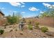 Backyard garden featuring a stone fountain, rock groundcover, lush greenery and a brick trim at 16 Via Stefano, Henderson, NV 89011