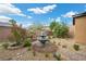 Backyard garden featuring a stone fountain, rock groundcover, lush greenery and a brick trim at 16 Via Stefano, Henderson, NV 89011