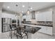 Bright kitchen features stainless steel appliances, sleek black counters and island with pendant lighting at 16 Via Stefano, Henderson, NV 89011
