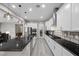 Contemporary kitchen with stainless appliances, dark counters, central island, and tile floors at 16 Via Stefano, Henderson, NV 89011