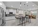 Bright kitchen with tile floors, stainless steel appliances, black countertops and central island at 16 Via Stefano, Henderson, NV 89011