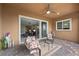 Covered patio area with stylish outdoor seating and sliding glass doors opening to the living room at 16 Via Stefano, Henderson, NV 89011