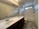 Bright bathroom features a bathtub/shower combo, dual sinks, and vanity with a mirror at 2112 Merganser Ct, North Las Vegas, NV 89084