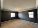 Spacious bedroom with two windows, neutral carpet, and dark colored walls at 2112 Merganser Ct, North Las Vegas, NV 89084