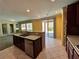 Open-concept kitchen features dark cabinetry, stainless steel appliances, and access to the backyard at 2112 Merganser Ct, North Las Vegas, NV 89084