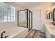 Bright bathroom features a modern shower, soaking tub, and dual sink vanity with elegant mirrors at 2470 Lower Meadows Ave, Henderson, NV 89052