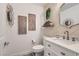 Charming powder room boasts stylish wallpaper, modern fixtures, floating shelf, and a decorative mirror at 2470 Lower Meadows Ave, Henderson, NV 89052