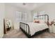 Bright bedroom with neutral carpet, a large window, a metal bed frame, and a full-length mirror at 2470 Lower Meadows Ave, Henderson, NV 89052