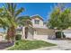 Inviting home with lush green lawn, mature palm trees, desert landscaping, and a tiled roof at 2470 Lower Meadows Ave, Henderson, NV 89052