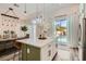 Beautiful kitchen with a view to the pool, featuring an island with seating and a dining area with modern light fixture at 2470 Lower Meadows Ave, Henderson, NV 89052