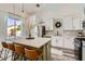Modern kitchen features stainless appliances, island with seating, and sliding glass doors to the pool area at 2470 Lower Meadows Ave, Henderson, NV 89052
