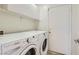 Laundry room with washer, dryer, overhead cabinets and access door at 2470 Lower Meadows Ave, Henderson, NV 89052