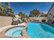 Beautiful backyard oasis featuring a pool, spa, waterfall, lush landscaping and inviting seating areas at 2470 Lower Meadows Ave, Henderson, NV 89052