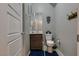 Well-lit half bathroom with a modern vanity, toilet, and decorative wall art at 253 Kindly Way, Henderson, NV 89011