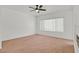 Inviting bedroom featuring soft carpet, a ceiling fan, and a large window for ample natural light at 2573 Grandville Ave, Henderson, NV 89052