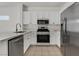 Well-equipped kitchen with white cabinets, stainless steel appliances, and a tile backsplash for a clean look at 2573 Grandville Ave, Henderson, NV 89052