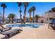 Resort-style pool area with lounge chairs, palm trees, and clear blue water for relaxation at 2725 S Nellis Blvd # 1056, Las Vegas, NV 89121