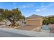 Charming single-story home showcasing desert landscaping, a spacious driveway, and mature trees at 2820 Goldcreek St, Henderson, NV 89052