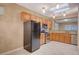 Kitchen with stainless steel appliances, wood cabinetry, granite countertops, skylight, and tile flooring at 2820 Goldcreek St, Henderson, NV 89052