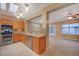 Well-lit kitchen featuring stainless steel appliances, granite countertops, wood cabinetry, and a tile floor at 2820 Goldcreek St, Henderson, NV 89052