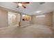 Open-concept living room with tile flooring, neutral paint, ceiling fan, and views of the kitchen and entryway at 2820 Goldcreek St, Henderson, NV 89052