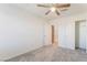 Cozy bedroom with gray carpet and ceiling fan, featuring doors to closet and hallway at 2824 Mozia Ct, Henderson, NV 89044