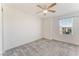 Bright bedroom features neutral walls, gray carpet, ceiling fan, and a window at 2824 Mozia Ct, Henderson, NV 89044