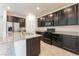 Modern kitchen features dark cabinets, stainless steel appliances, and a large island with granite countertops at 2824 Mozia Ct, Henderson, NV 89044