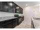 Stylish kitchen boasting dark cabinetry, granite countertops, and modern appliances for a sleek look at 2824 Mozia Ct, Henderson, NV 89044