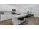 Open kitchen view of the island with white cabinets, marble countertops, stainless steel appliances, and breakfast table at 2935 Gaffer Film St, Las Vegas, NV 89156