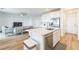 Bright open concept kitchen features white cabinets, stainless appliances, island, and view of the living room at 2935 Gaffer Film St, Las Vegas, NV 89156