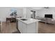View of kitchen island with marble countertops, sink, and open concept view of dining and living room at 2935 Gaffer Film St, Las Vegas, NV 89156